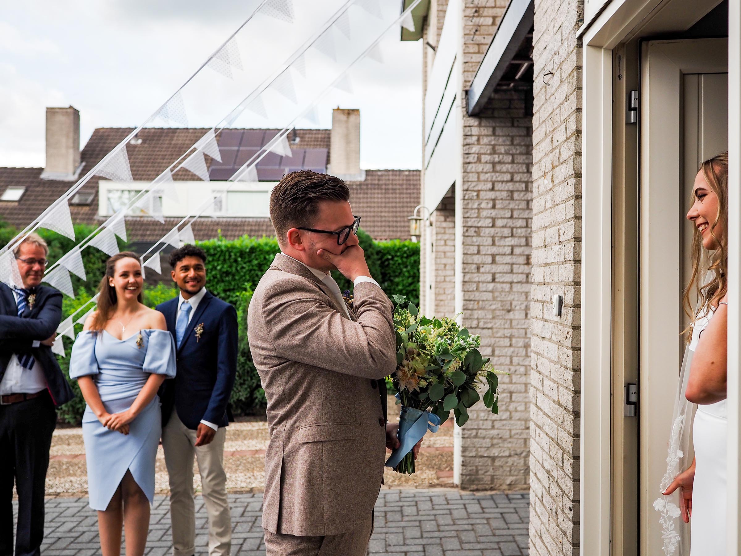 Bruidegom onder de indruk van de bruid bij het openen van de deur